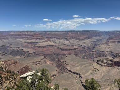 Un vaste paysage du Grand Canyon sous un ciel bleu.